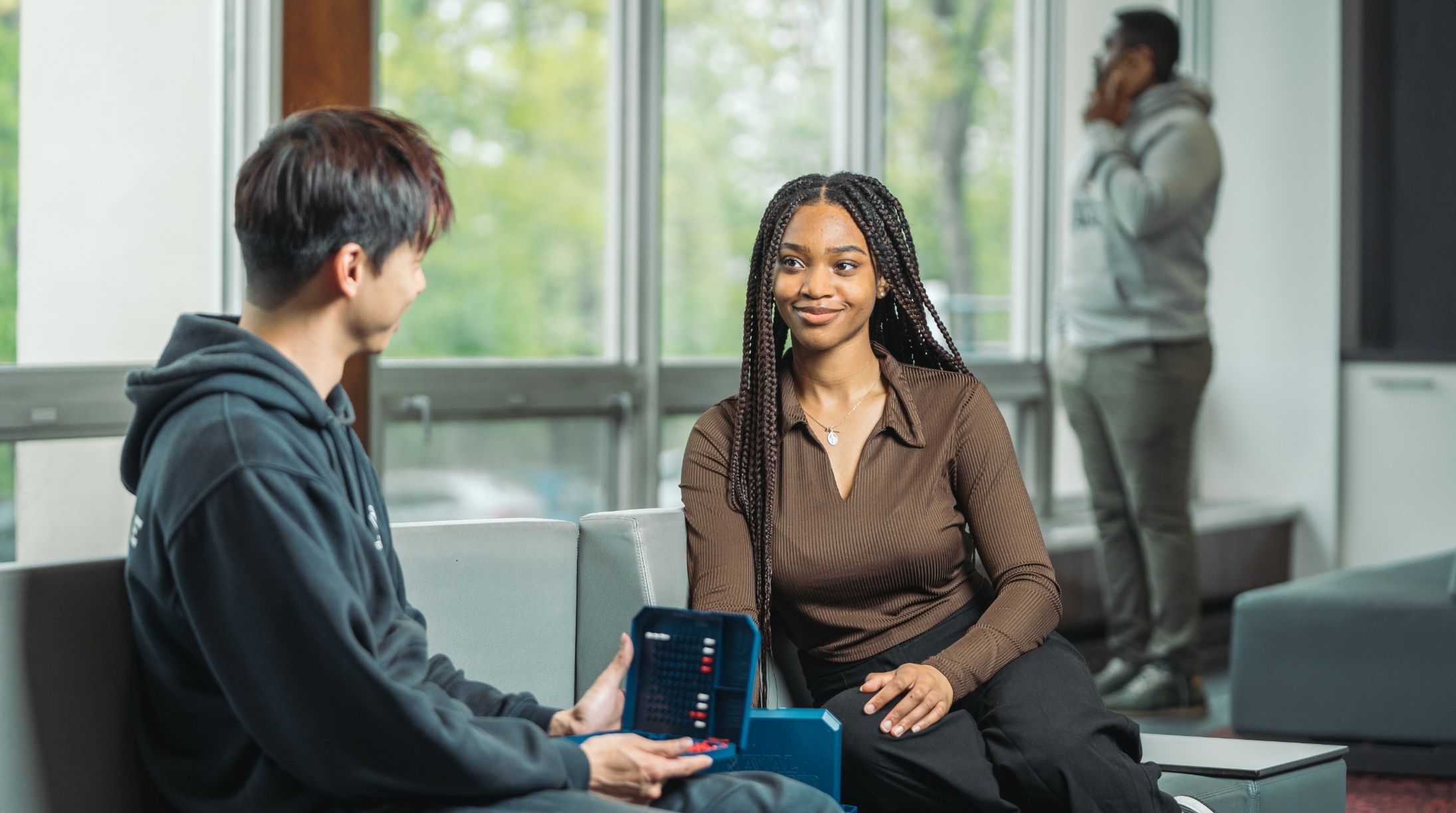 Un étudiant et une étudiante qui discute dans une aire commune