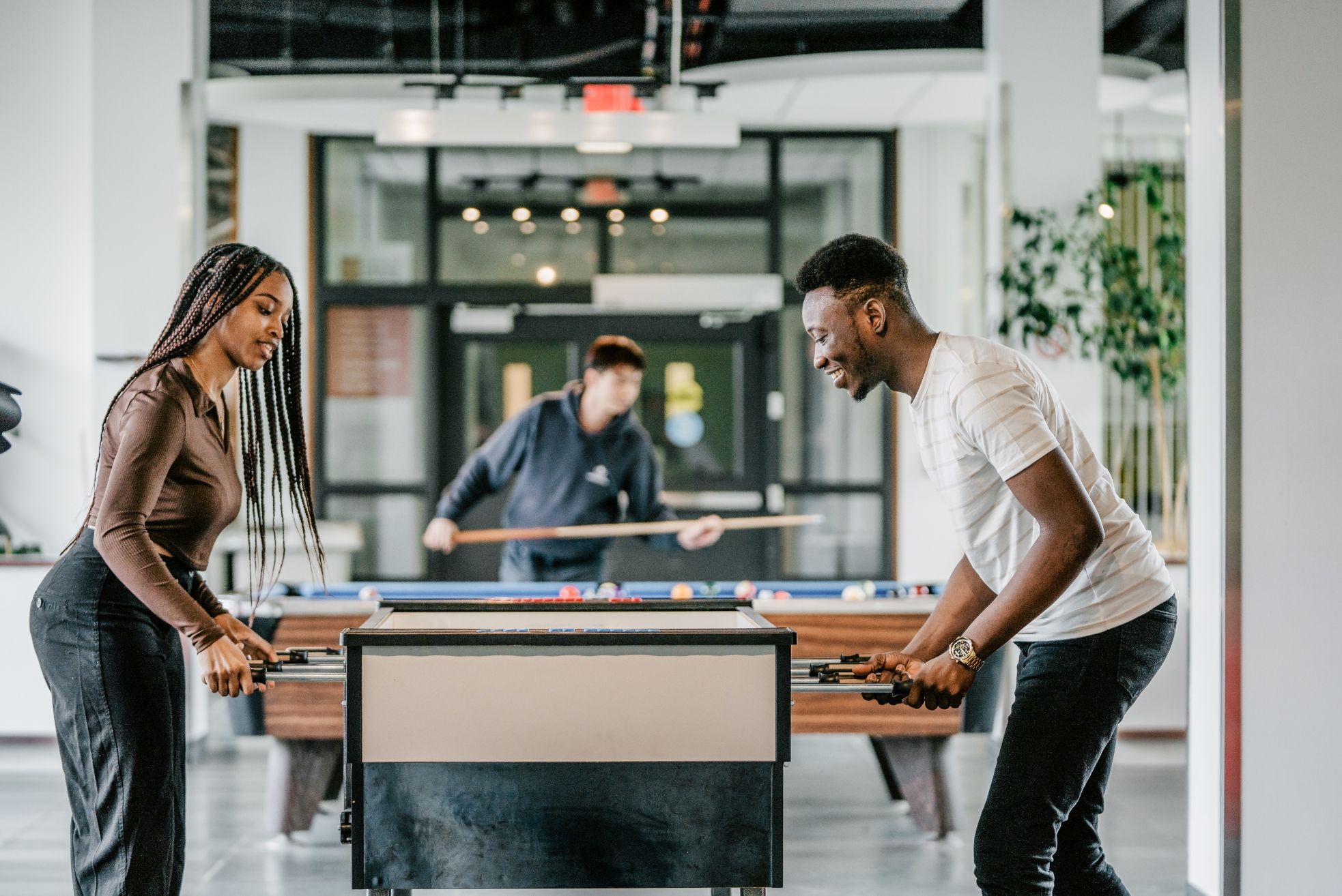 Étudiante et étudiant jouant au hockey sur table